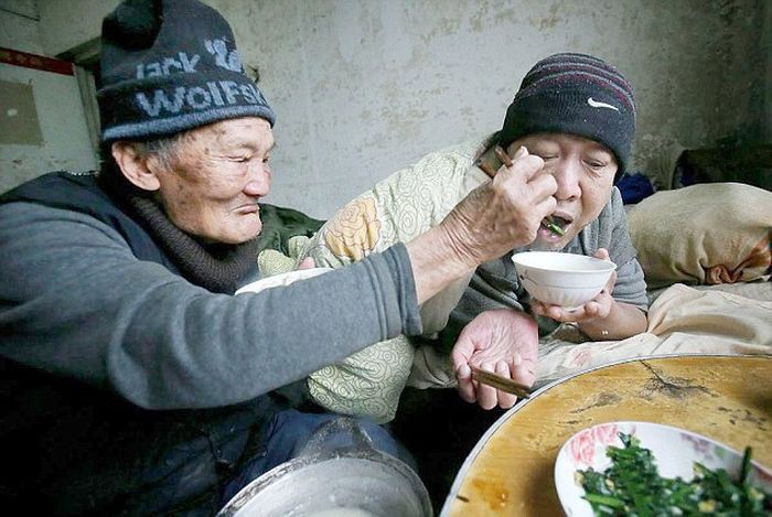 صور : صيني يبلغ من العمر 95 عام يعتني بإبنه المشلول ذو 65 عام